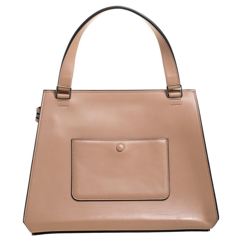 This Celine Edge bag is not only visually magnificent but also functional. It has been crafted from leather and styled with a silhouette that is classy and posh. The beige bag has a top handle and a top zipper that reveals a spacious interior. The