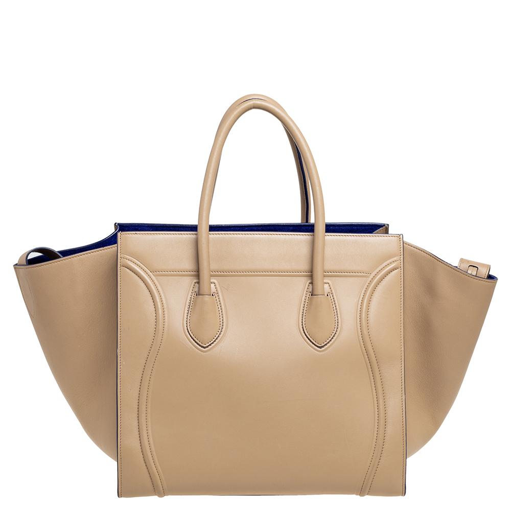 Celine released the Phantom as a newer version of their successful Luggage model. Unlike the Luggage toes, the Phantom has an open-top, wider wingspans, and a braided zipper pull. We have here the one in leather in a beige shade. It has two top