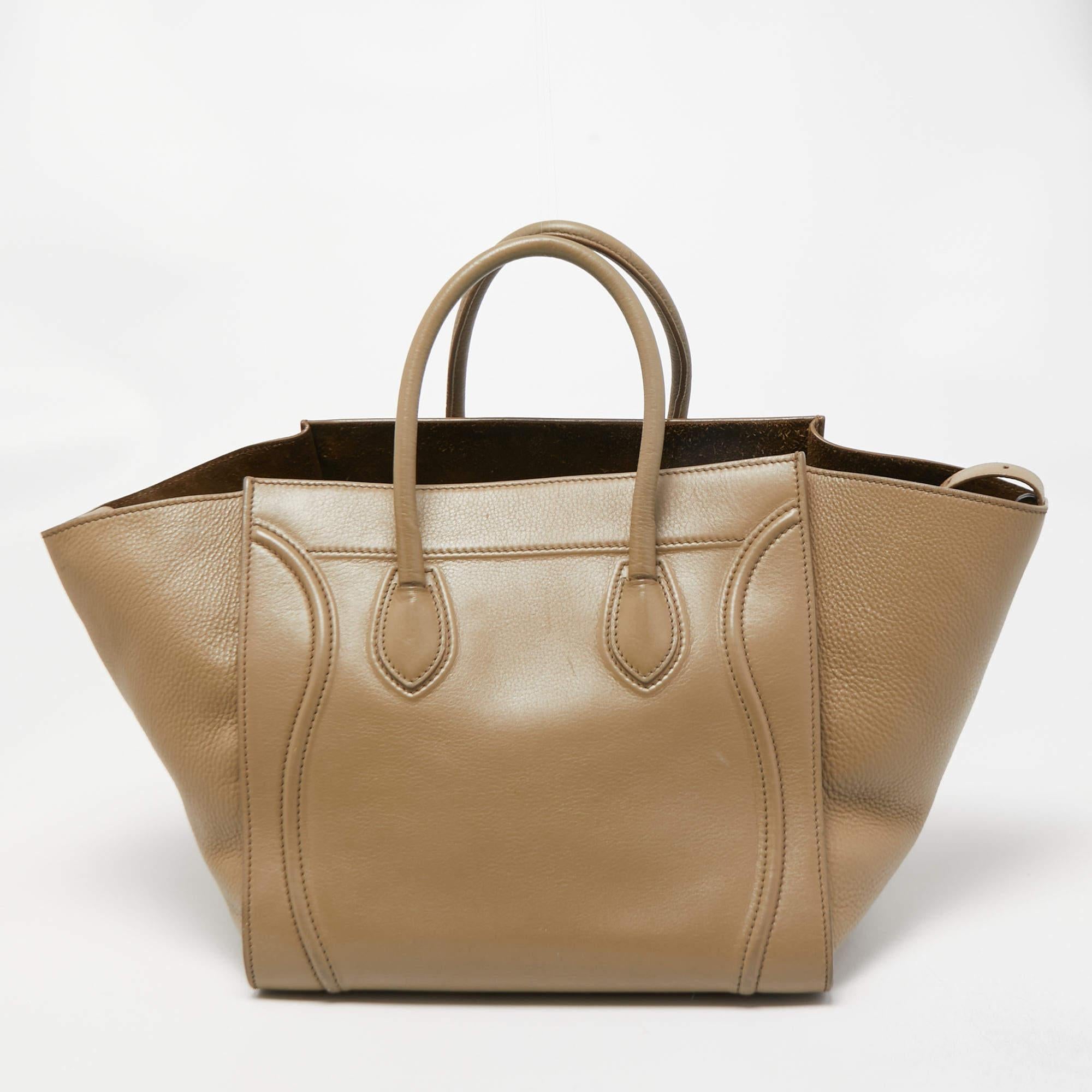 Celine released the Phantom as a newer version of its successful Luggage model. Unlike the Luggage toes, the Phantom has an open-top, wider wingspans, and a braided zipper pull. We have here the one in leather. It has two top handles, a beige shade,