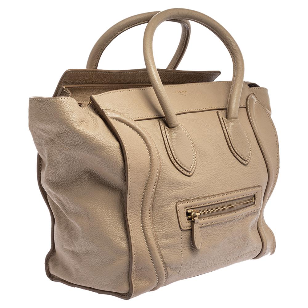 The mini Luggage tote from Celine is one of the most popular handbags in the world. This tote is crafted from leather and designed in a beige shade. It comes with rolled top handles and a front zip pocket. The bag is equipped with a well-sized