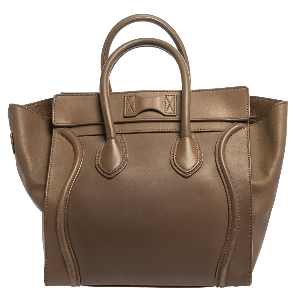 The mini Luggage tote from Celine is one of the most popular handbags in the world. This tote is crafted from leather and designed in a beige shade. It comes with rolled top handles, protective metal feet, and a front zip pocket. The bag is equipped