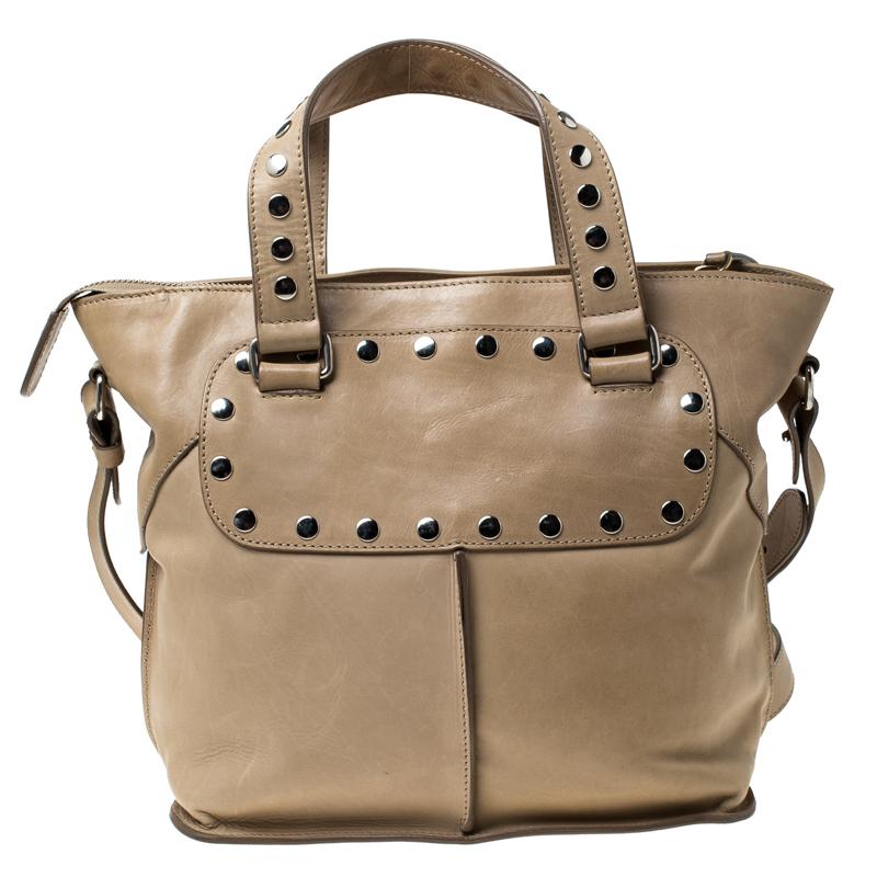 This feminine tote from Celine is your ideal everyday accessory. This gorgeous tote in a beautiful shade of beige has a leather body that is adorned with metallic studs and the fabric lined interior has enough space to carry all your essentials with
