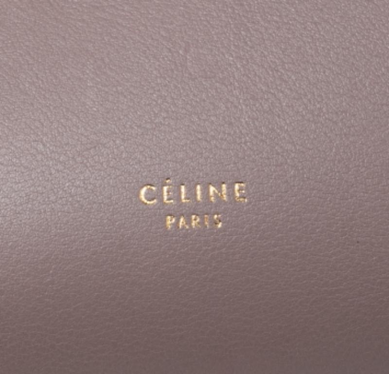 Taschen von Celine sind ein Symbol für exzellente Handwerkskunst und zeitloses Design. Diese beige/navyblaue Kreation wurde aus Leder gefertigt und mit einer Umschlagklappe und geknoteten Gürteldetails versehen. Sie verfügt über einen einzigen Griff