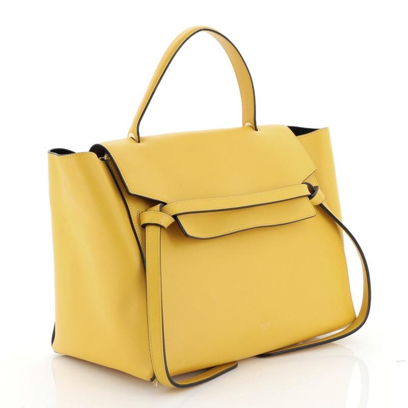 This Celine Belt Bag Calfskin Mini, crafted from yellow calfskin, features a single looped top handle, exterior back zip pocket, frontal flap, and gold-tone hardware. Its zip closure opens to a black suede interior with slip pockets.

Estimated