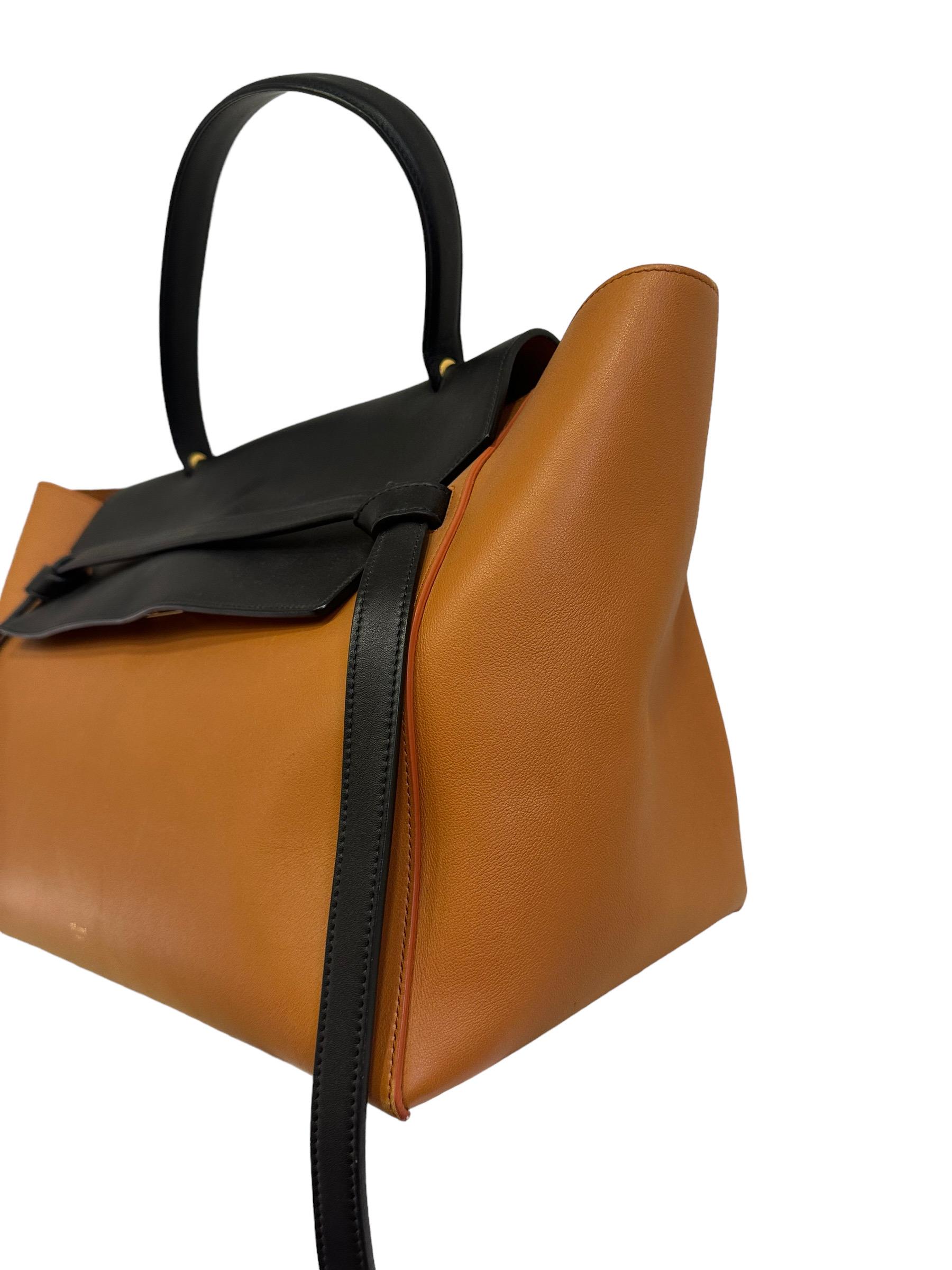 Bag by Celine, Belt model, made in two-tone black and orange leather with gold hardware. Equipped with a central handle in black leather, internally lined in dark orange suede, very roomy. Equipped with a flap with interlocking closure, an external