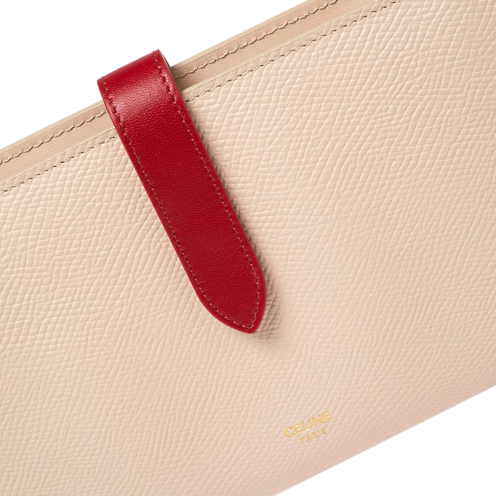 A beautiful wallet for stylish women, this Celine multifunction wallet is perfect to be carried solo while you step out to run errands. Crafted in leather, this wallet has contrasting shades, the brand detail on the front, and a simple strap