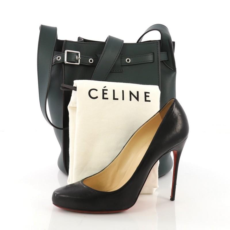 This Celine Big Bag Bucket Leather, crafted in green leather, features long leather strap and silver-tone hardware. Its belt drawstring closure opens to a green suede interior with side slip pocket. **Note: Shoe photographed is used as a sizing