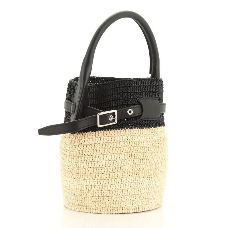 This Celine Big Bag Bucket Woven Raffia Nano, crafted from black and neutral woven raffia, features rolled leather handle, belt detail and silver-tone hardware. It opens to a black and neutral raffia interior. These are professional pictures of the