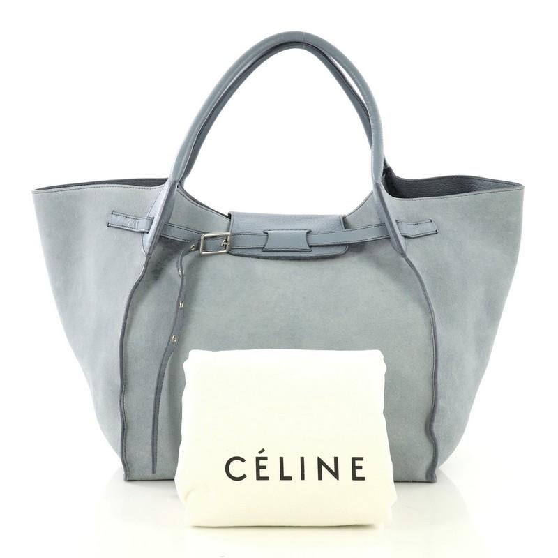 This Celine Big Bag Suede Medium, crafted in light blue suede and leather, features dual rolled handles, belt detail on the front, and silver-tone hardware. It opens to a light blue leather interior with zip pocket. 

Estimated Retail Price: