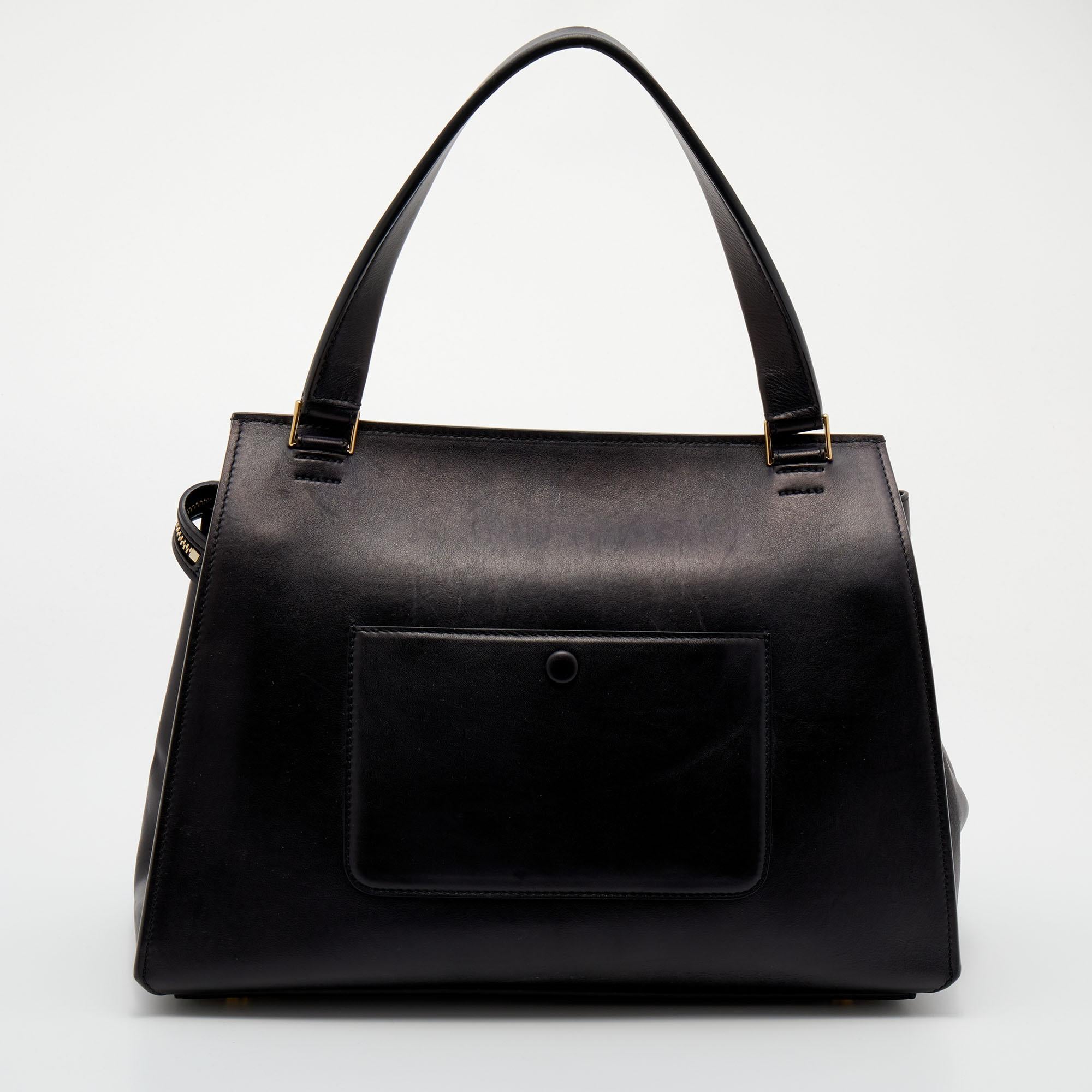 This Edge bag from the House of Celine exudes the right amount of class and style. Crafted from black-beige leather, this bag is adorned with a top handle and gold-tone hardware. It accommodates a leather-lined interior. Make this classy Celine bag