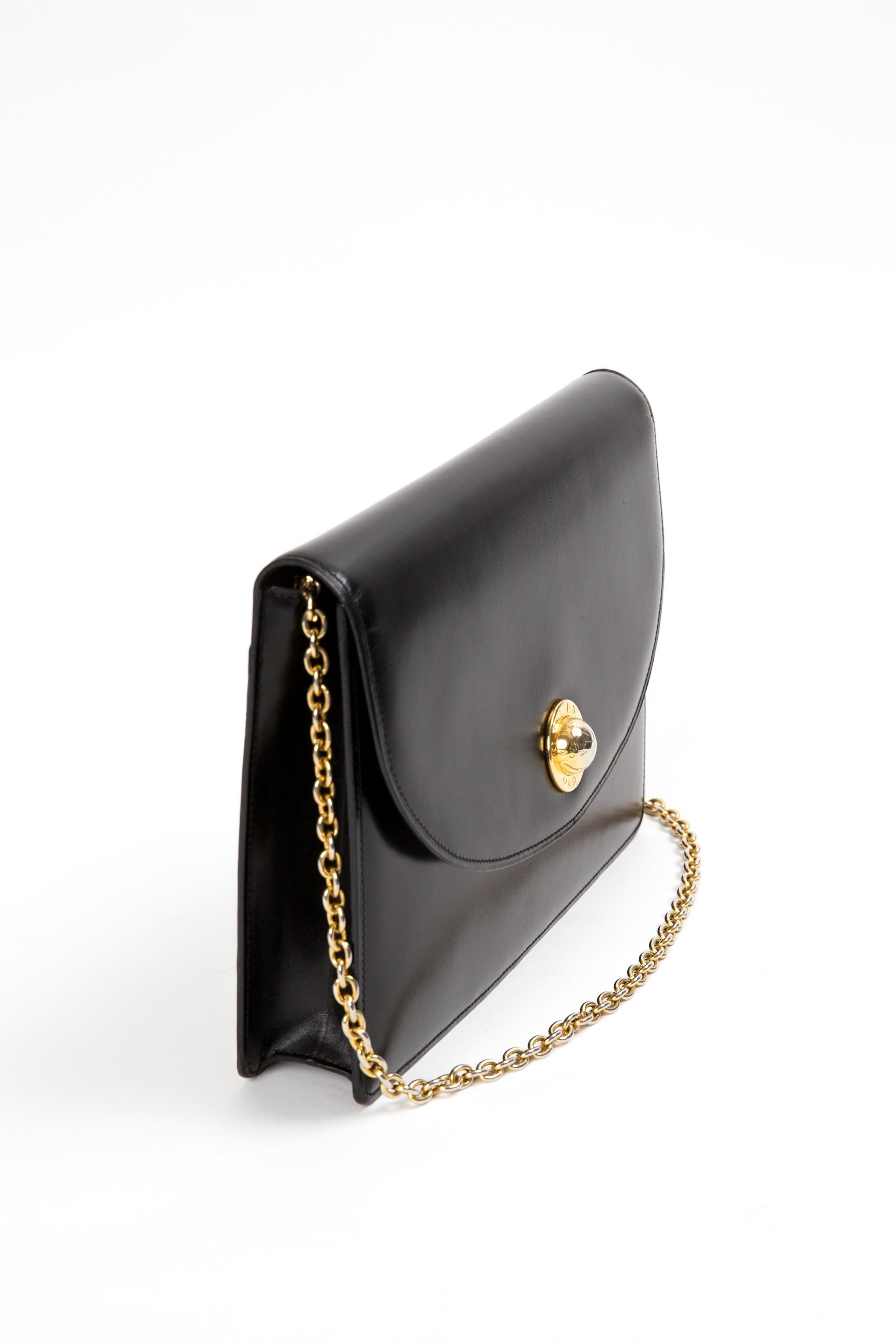 Celine black box leather shoulder bag featuring a front gold-tone logo with an under snap opening, a back flat pocket, inside compartments, a long gold-tone shoulder strap, a red leather inside lining. 
Circa 1990s. Made in France.
In good vintage