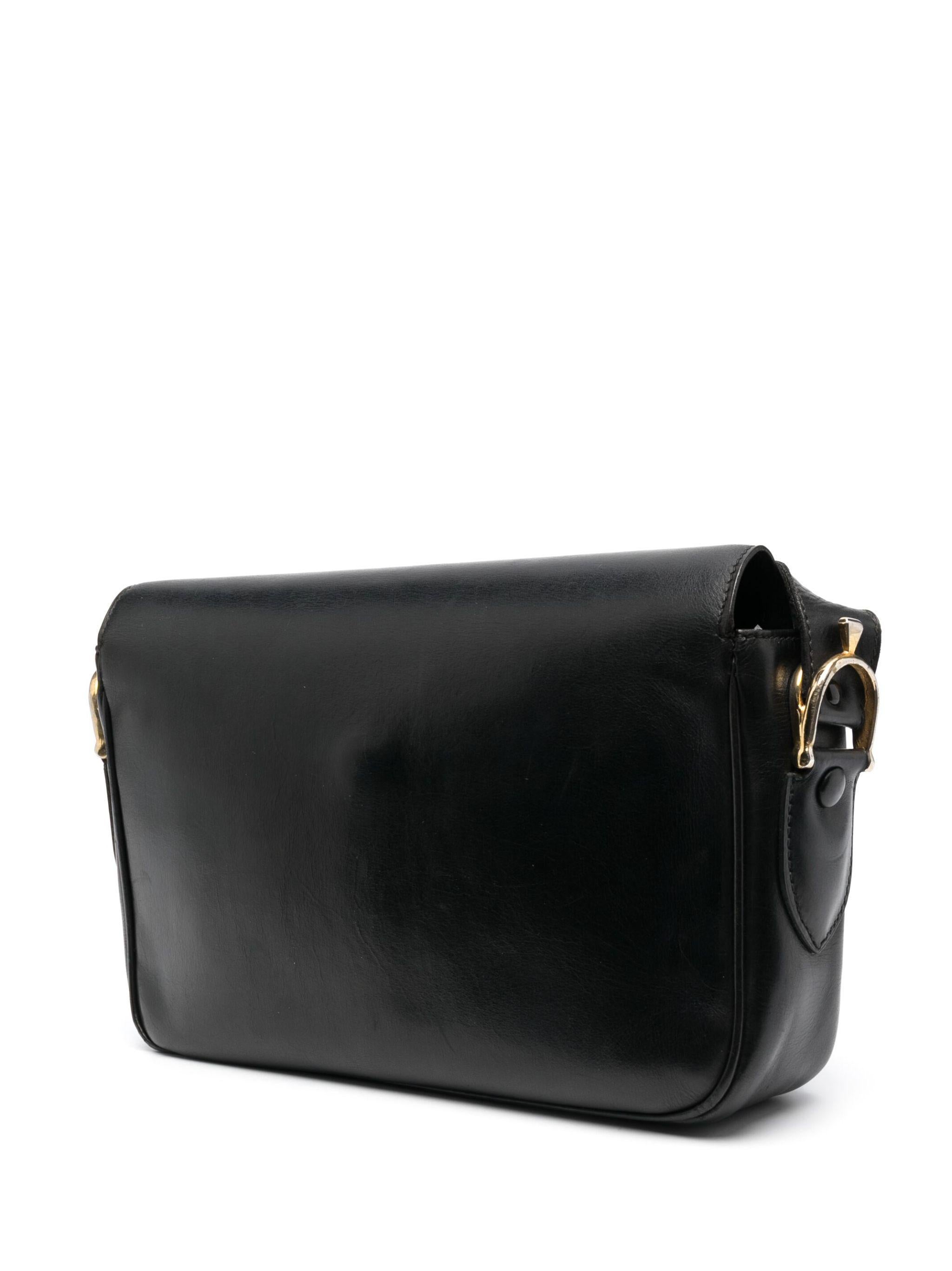 Bolso bandolera Celine de piel en caja negra con herrajes en tono dorado envejecido y cierre frontal, correa ajustable para hombro/cuerpo cruzado, forro de piel tonal con cremallera interior y bolsillo portaobjetos.
Alrededor de 1970. Fabricado en