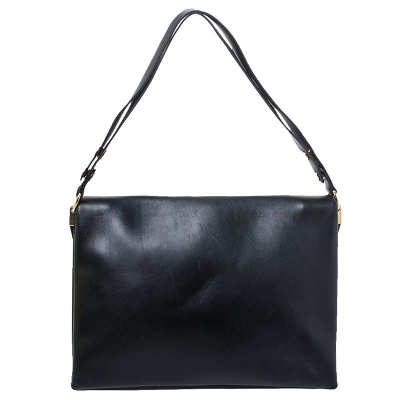 Carry along a mark of sophistication with this simple yet attractive Celine bag. It has been crafted in black calfskin leather. The bag features a top handle and flap closure with blade gold-tone detailing. The interior has two open compartments and