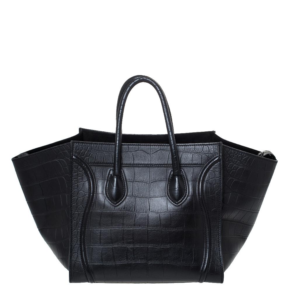 Celine released the Phantom as a newer version of their successful Luggage model. Unlike the Luggage toes, the Phantom has an open-top, wider wingspans, and a braided zipper pull. We have here the one in croc-embossed leather. It has two top
