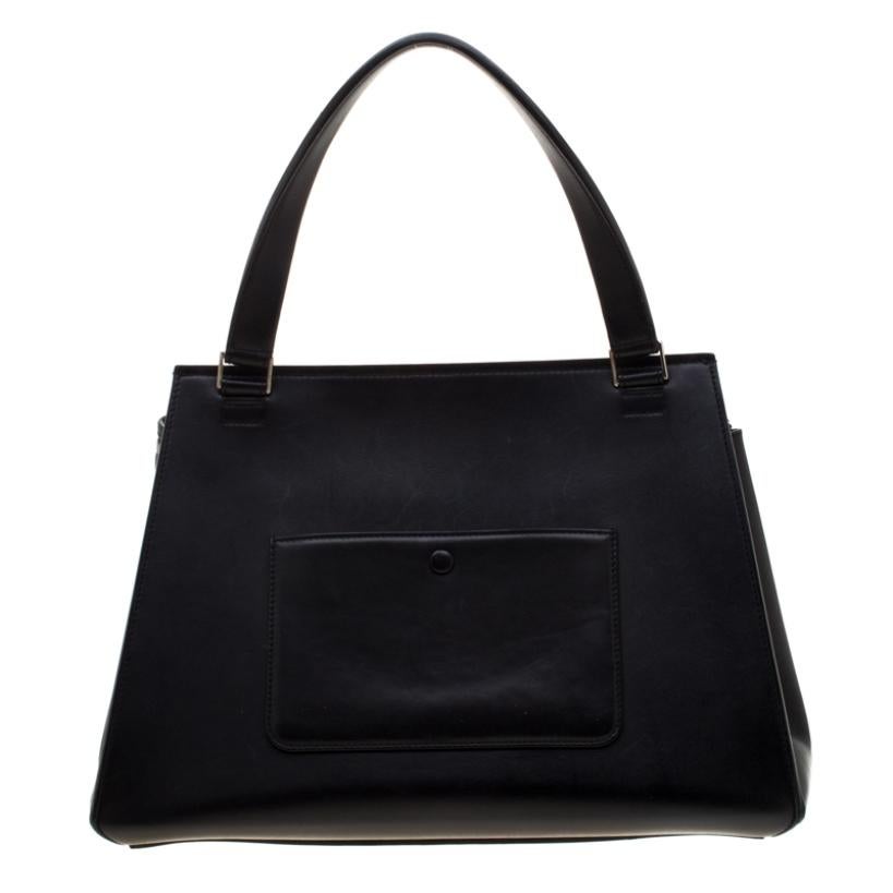 This Celine Edge bag is not only visually magnificent but also functional. It has been crafted from black leather, grey calf hair and styled with a silhouette that is classy and posh. The bag has a top handle and a top zipper that reveals a spacious