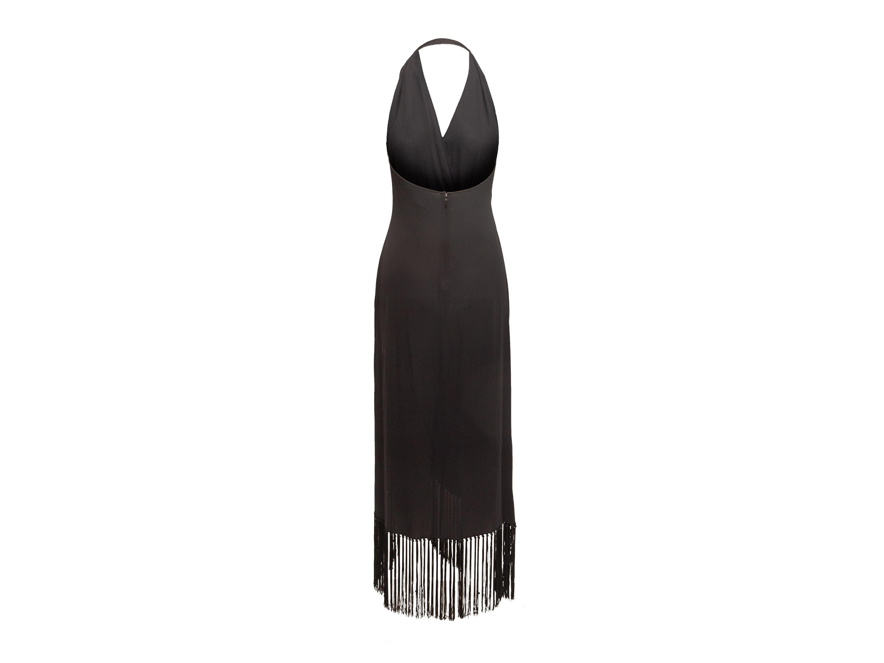 Product details: Black halter maxi dress by Celine. Surplice neckline featuring draping. Fringe trim at hem. Zip closure at back. 24