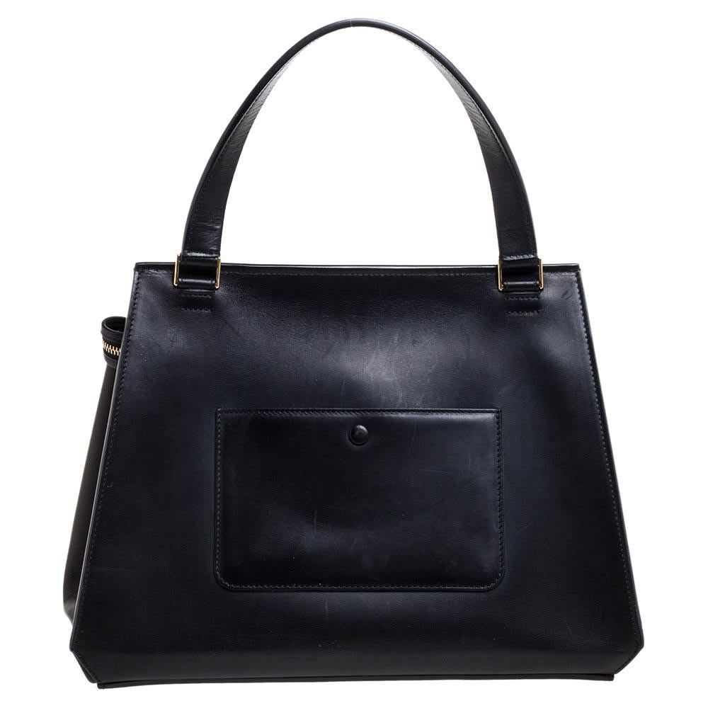 This Céline Edge bag is not only visually magnificent but also functional. It has been crafted from ivory canvas and black leather into a classy silhouette. The bag has a top handle and a front zipper that reveals a spacious interior. The gorgeous
