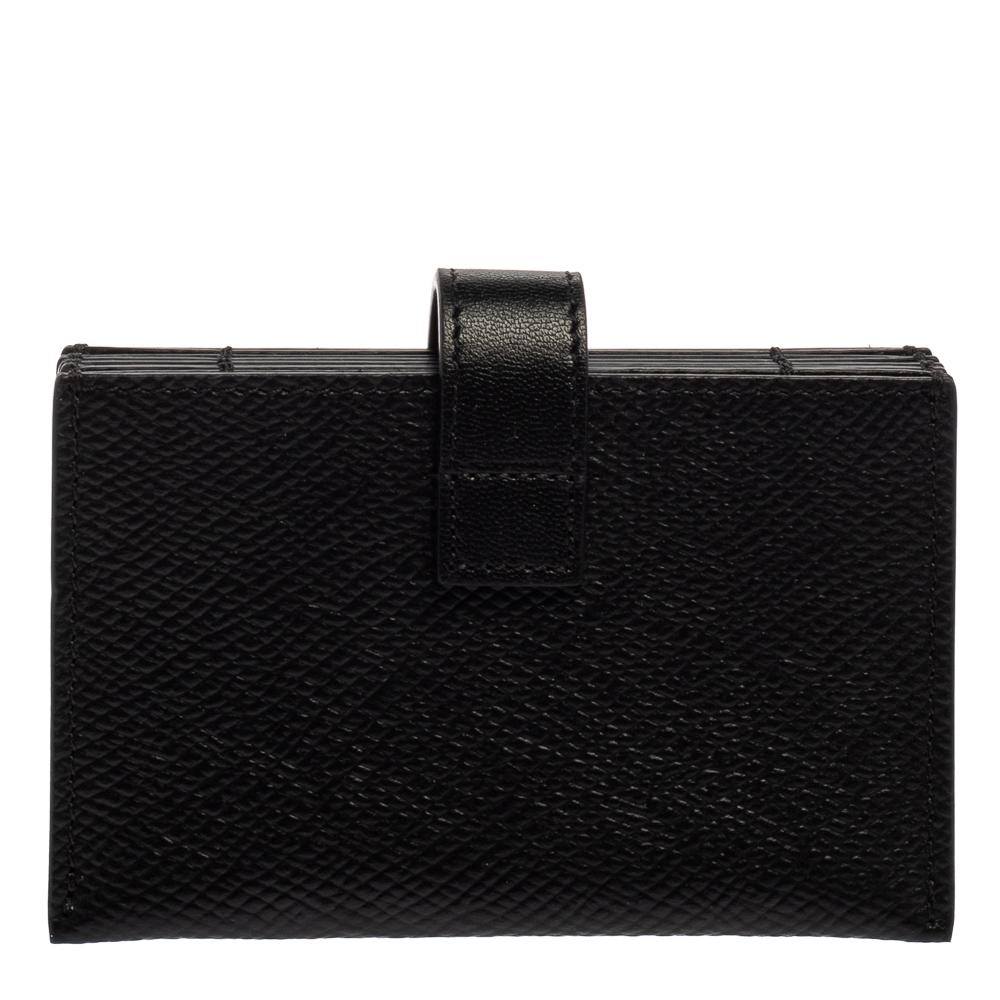 Bringing elegance and class to your pocket, this cardholder from Celine is stylish and convenient. Crafted from black leather, it features a slender strap that secures with a snap button. Slide it inside bigger bags for easy organization of your