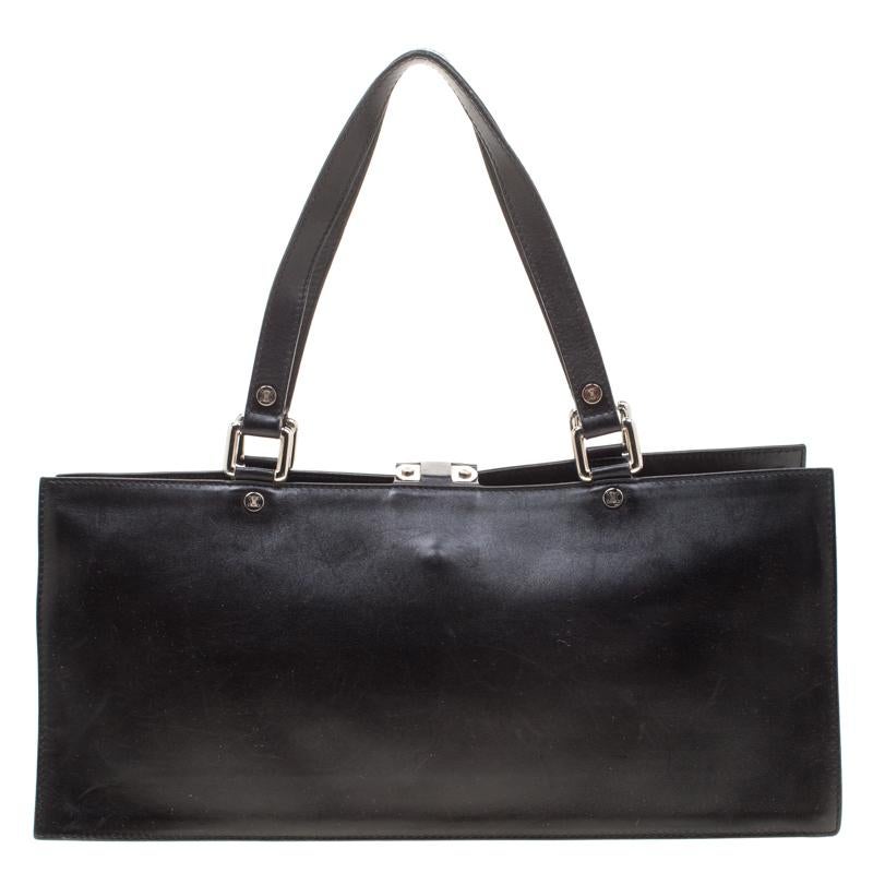 Carry your daily essentials in this black bag by Celine. Crafted from subtle leather, this petite tote is designed in a structured silhouette and is detailed with a buckle flap at the front. The interior is lined with canvas and features a zip