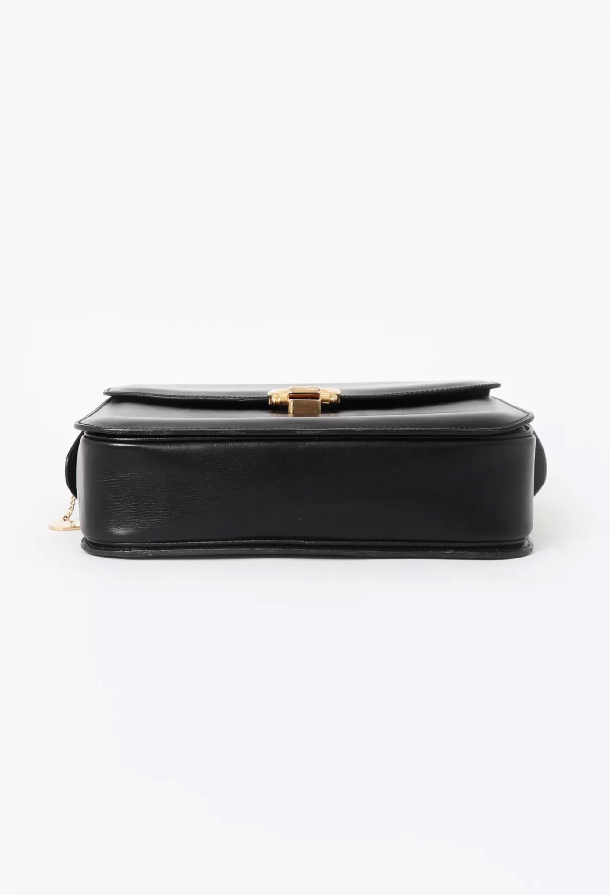Celine Black calfskin leather top handle bag featuring gold tone hardware,  a signature Caleche front closure, leather lining with three inner compartments and a zipper pocket. Circa 1990s  . 
In good vintage condition. Made in France.
We guarantee