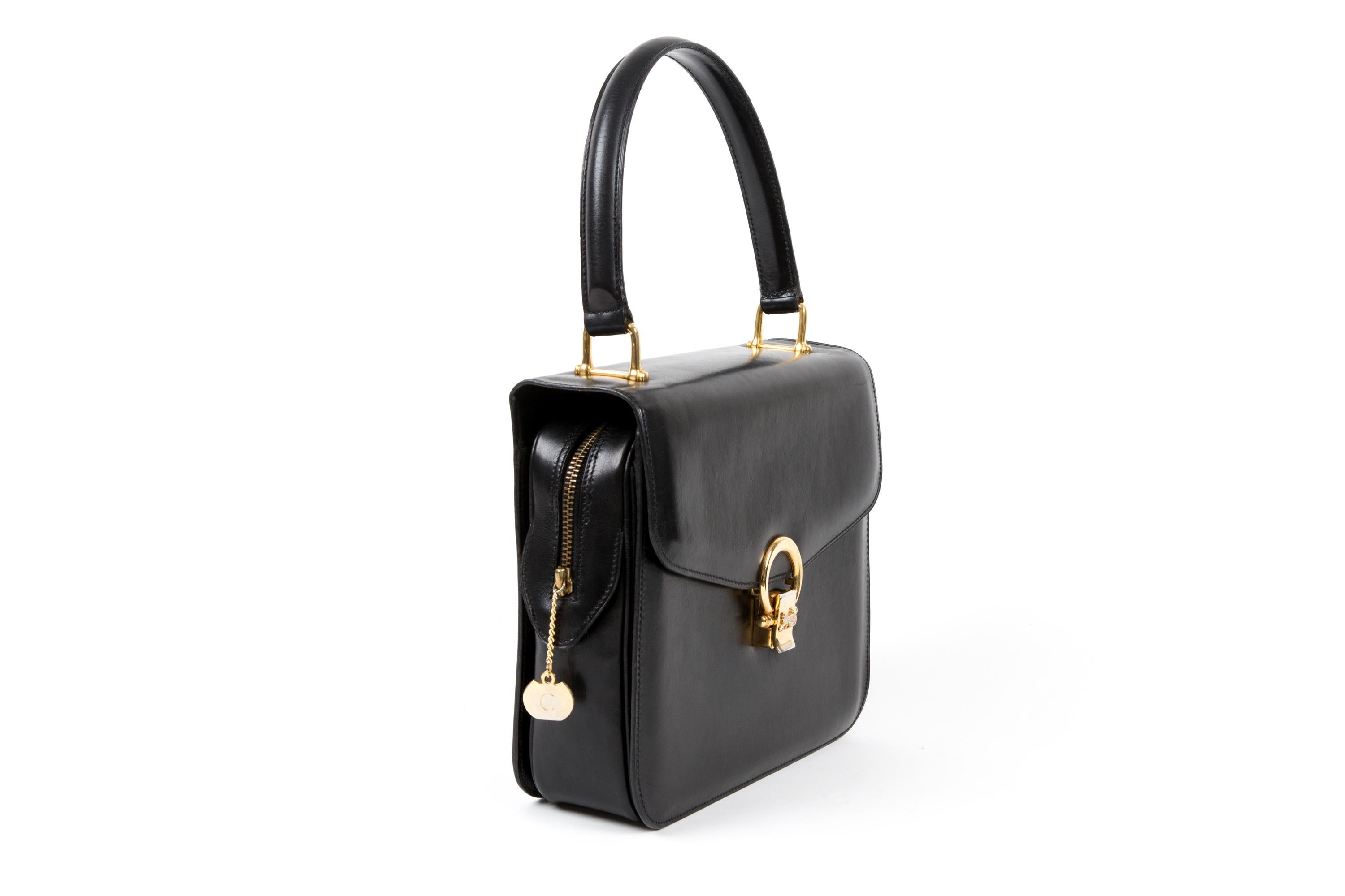 Celine black leather Caleche hand bag featuring gold tone hardware, a top leather handle, “Caleche” front closure, leather lining, inside three compartments and a zipper pocket . 
Circa 1990s. 
In good vintage condition. Made in France.
We guarantee