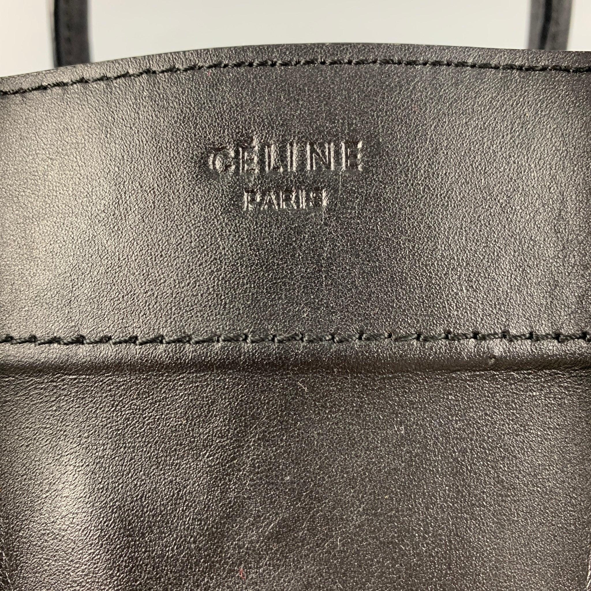 CELINE handbag comes in black calfskin leather featuring rolled leather top handles and decorative leather detailing, black suede interior with zipper and patch pockets.Good Pre-Owned Condition. Moderate signs of wear, and missing zipper pull on the