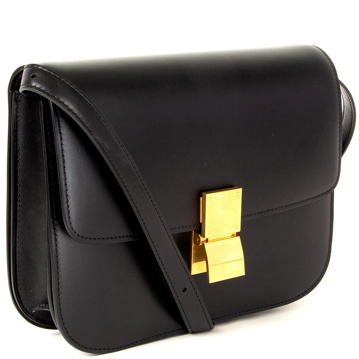 100% authentic Céline 'Medium Classic Bag' in black box calfskin. Opens with a push-lock on the front. The inside is divided into two compartments with two open pockets against the front and a zipper pocket against the back. Lined in black lambskin.