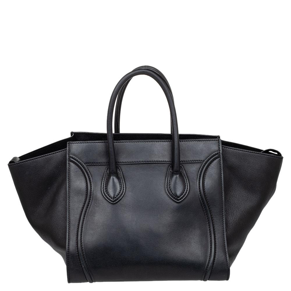 Celine released the Phantom as a newer version of their successful Luggage model. Unlike the Luggage toes, the Phantom has an open-top, wider wingspans, and a braided zipper pull. We have here the one in leather. It has two top handles, a black