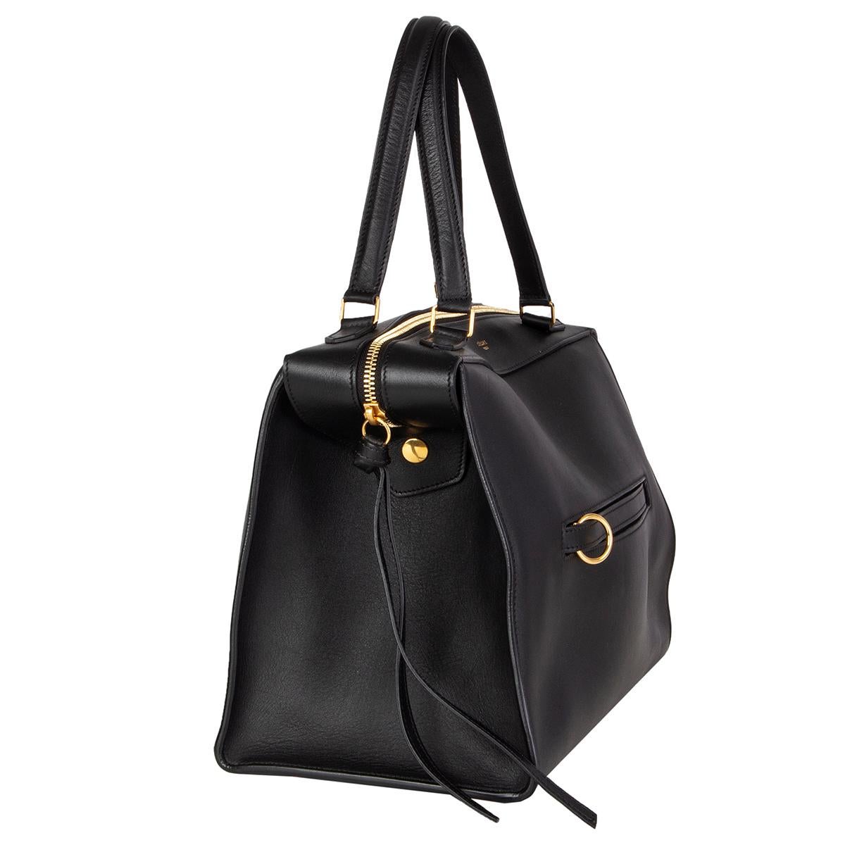 Céline 'Small Ring' handbag in black smooth calfskin with a ring zip pocket at front featuring gold-tone hardware. Opens with a zipper on top and is lined in midnight blue suede with one zip pocket against the back and two slit pockets attached. Has