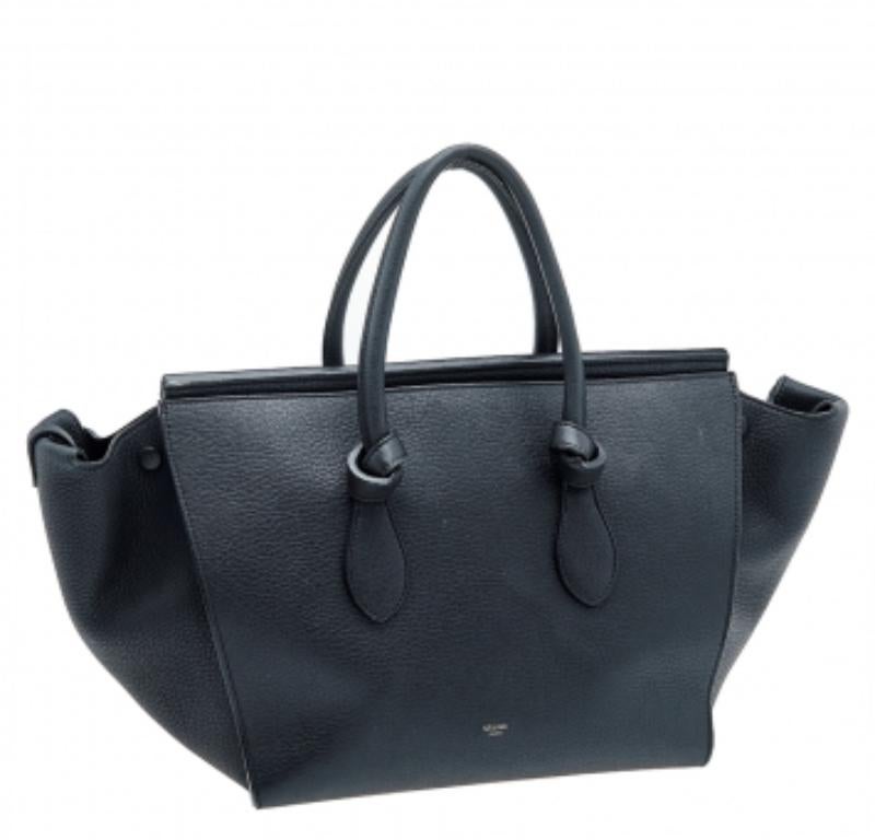 This Tie tote is absolutely a must-have for your luxury collection. The House of Celine brings us this Tie tote that will make you look classy! It is made from black leather, with gold hardware elevating its beauty. It is completed with dual sturdy