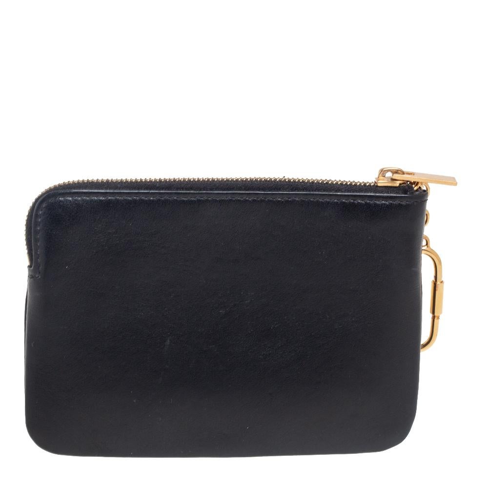 This coin purse is a suave creation from the extraordinary House of Celine. It flaunts an exterior made from black leather with logo wording inscriptions highlighting the front. It comes with a gold-toned key chain. Effortlessly store your monetary