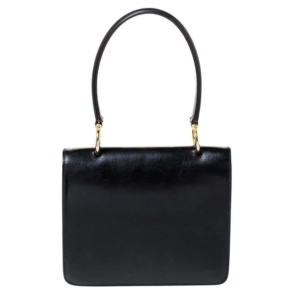 This vintage bag hails from the house of Celine. Crafted from quality leather, it carries a classic black hue that will complement a host of ensembles. It has a front flap that carries the brand logo on a gold-tone closure. It opens to a leather