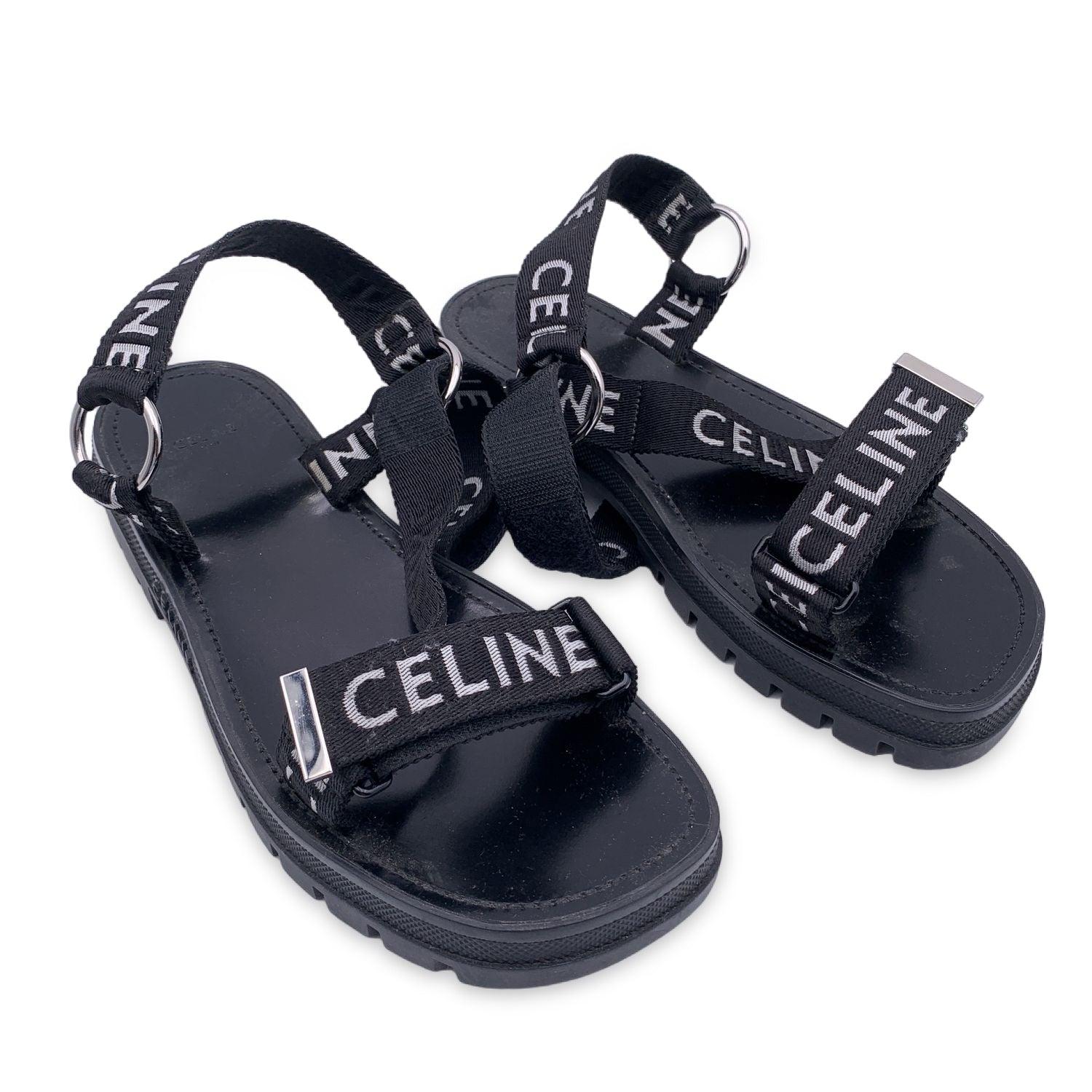 Celine 'Leo' strappy sandals in black color. Straps in fabric wth contrast 'Celine' jacquard writing. Strap with scratch to adjust the shoe onto the foot. Chunky lug rubber outsoleleather insole. Heel height : 4.5 cm / 1.8 inches. Made in Italy