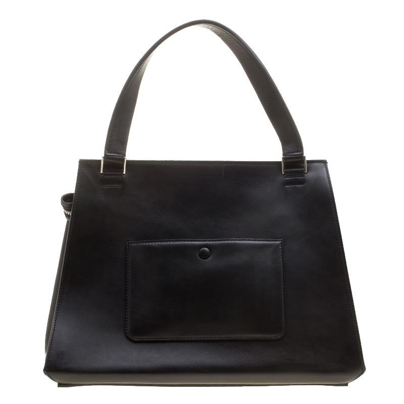 This Celine Edge bag is not only visually magnificent but also functional. It has been crafted from black leather, pink calf hair and styled with a silhouette that is classy and posh. The bag has a top handle and a top zipper that reveals a spacious