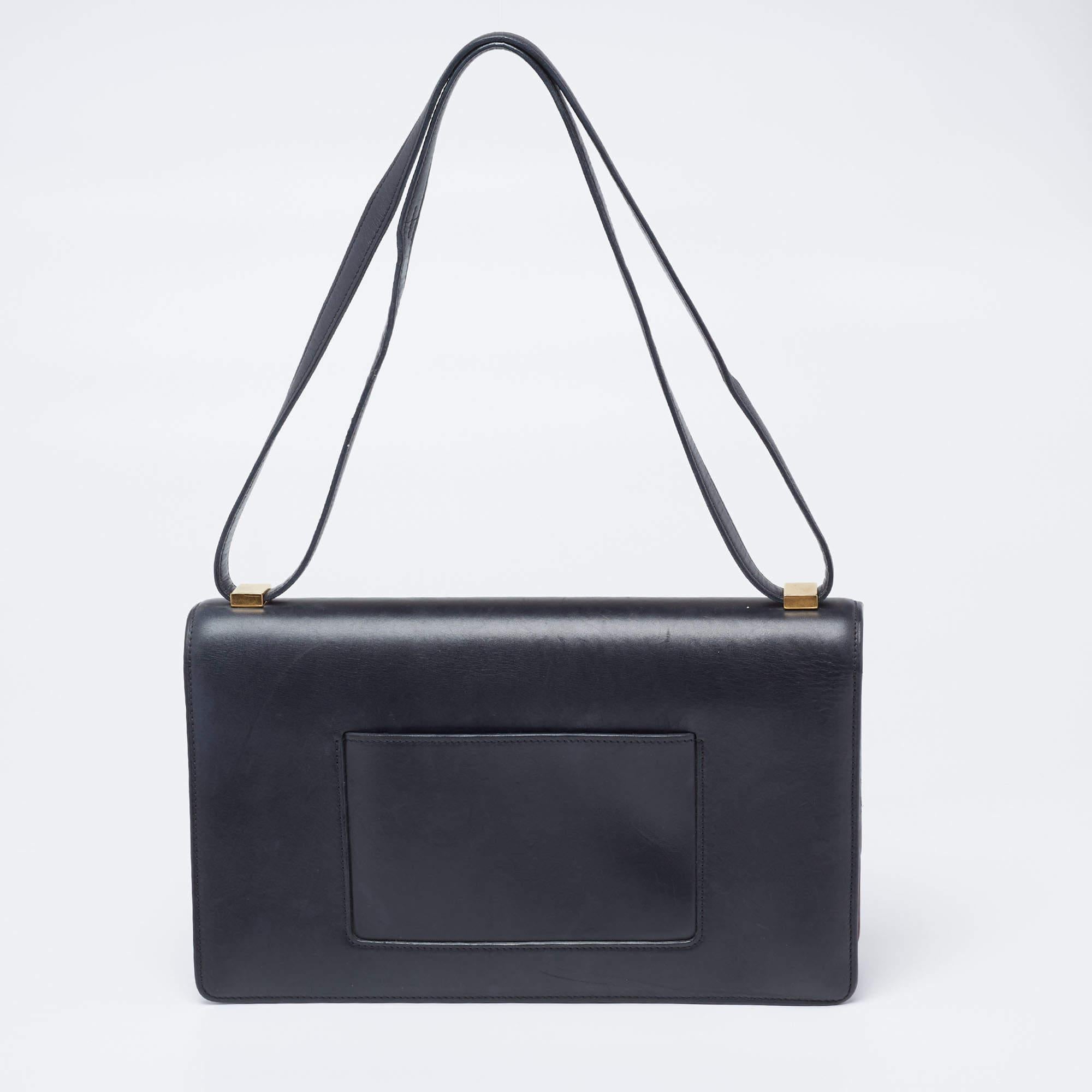 This Case bag from the house of Celine will be a classy companion with formals as well as casuals. Crafted from leather in red and black, the bag features a minimalistic design. The lock closure on the front flap opens to a compartmentalized