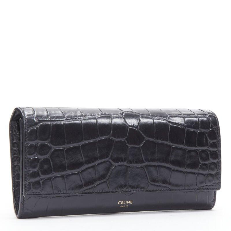 CELINE black scaled leather embossed calfskin flap front long wallet
Reference: KEDG/A00251
Brand: Celine
Designer: Hedi Slimane
Material: Calfskin Leather
Color: Black
Pattern: Animal Print
Closure: Snap Buttons
Lining:  Leather
Extra Details: Zip