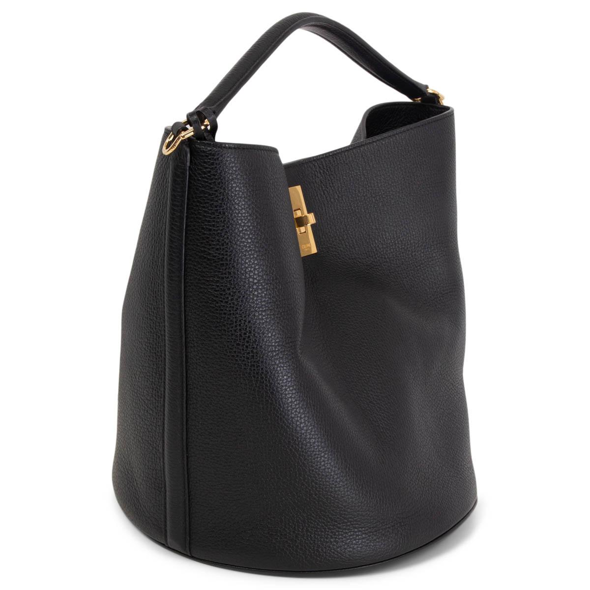 100% authentic Celine Bucket 16 Bag in black supple grained calfskin that features a gold-tone turn-lock closure. Lined in black suede. The bag comes with a removable zipper pouch. Removable shoulder-strap is missing. Has been carried and is in