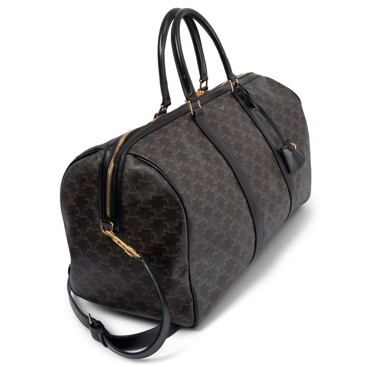 100% authentic Celine large travel duffle bag in black and brown Triomphe canvas and trimmings in black calfskin featuring gold-tone hardware. Opens with a double zipper on top and is lined in ochre cotton canvas. Has been carried and shows some