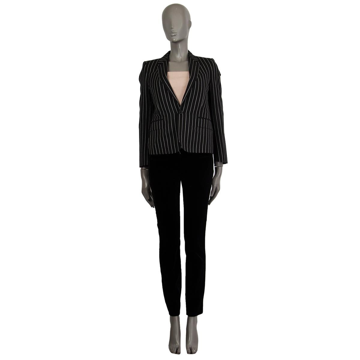 authentic Celine classic pinstripe blazer in black and white wool (100%) with a notch collar. Has two front decorative flap pockets. Closes on the front with a button. Lined in viscose (52%) and cupro (48%). Has been worn and is in excellent