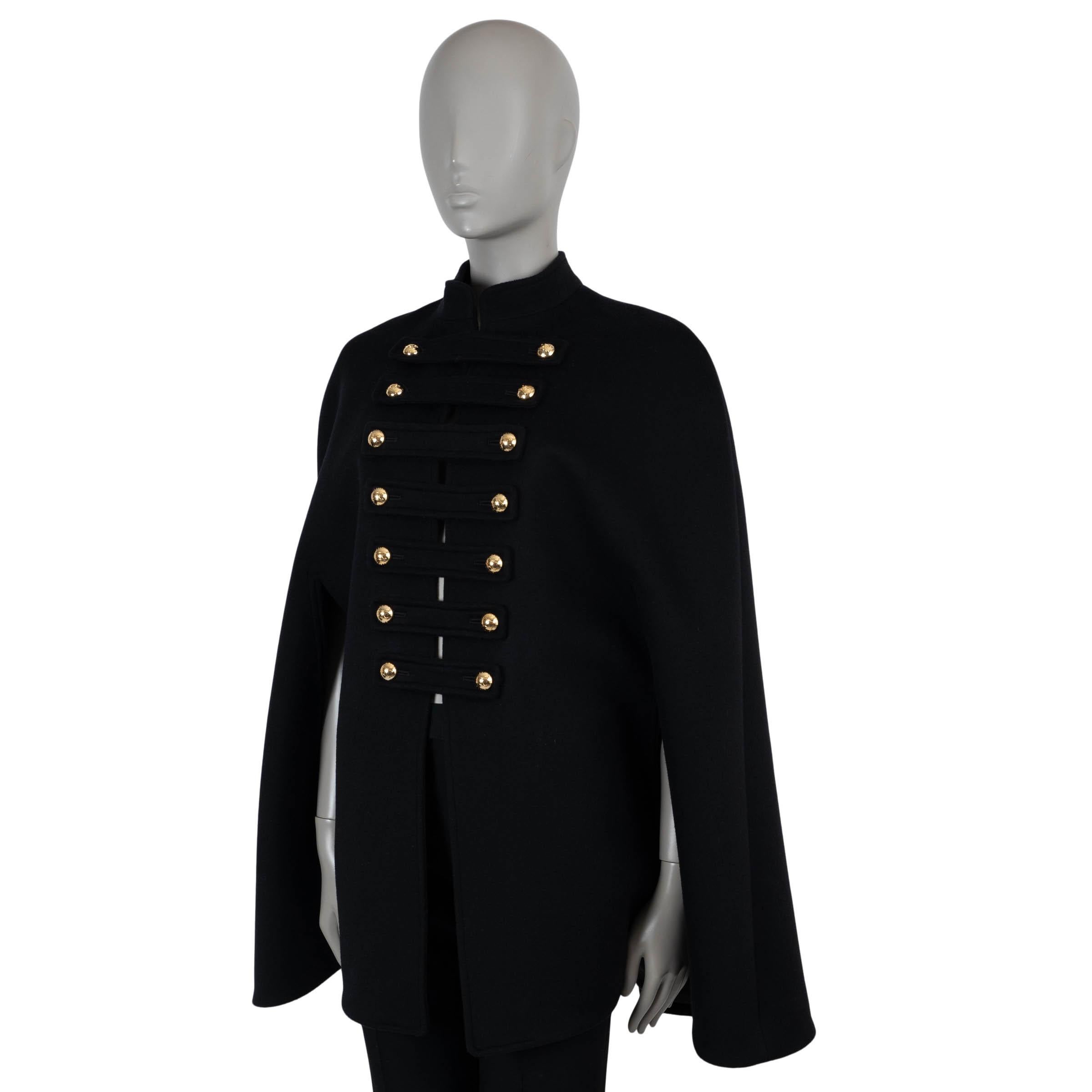 Questa mantella da ufficiale Celine, autentica al 100%, in feltro di lana nero (95%) e cashmere (5%), incarna un'eleganza strutturata con un tocco drammatico. Con una vestibilità ampia e un colletto alto, presenta 14 bottoni a mezza sfera firmati