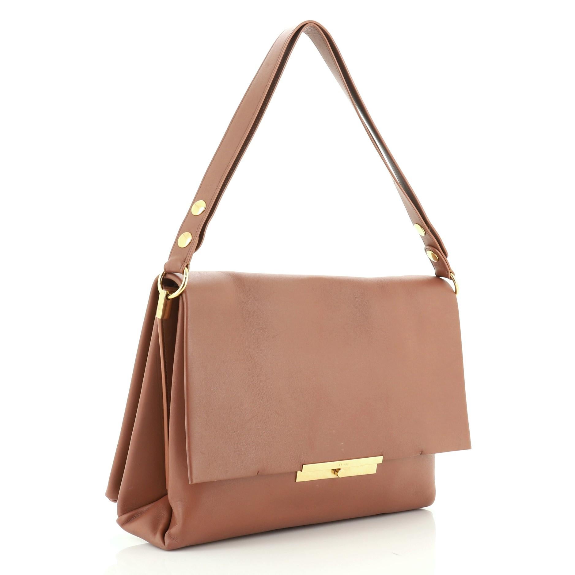 This Celine Blade Shoulder Bag Leather, crafted from brown leather, features a flat leather strap and gold-tone hardware. Its flap opens to a neutral suede interior with slip pockets. 

Estimated Retail Price: $3,100
Condition: Great. Minor wear and
