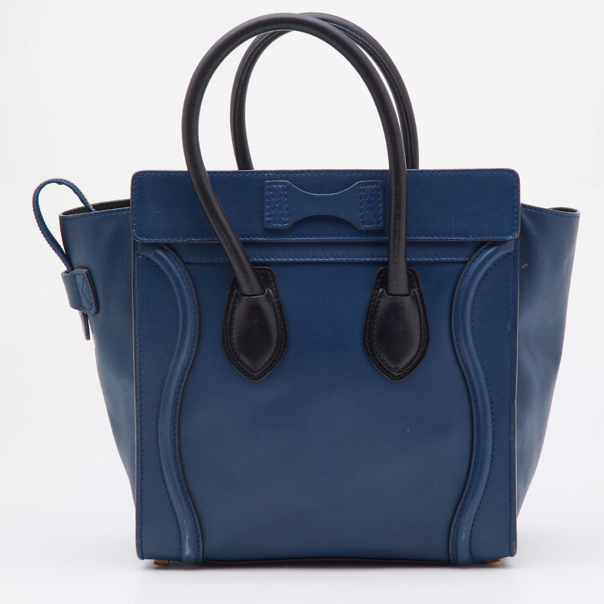The Luggage tote from Celine is one of the most popular handbags in the world. This tote is crafted from leather and designed in a blue & black hue. It comes with rolled top handles and a front zip pocket. The bag is equipped with a well-sized