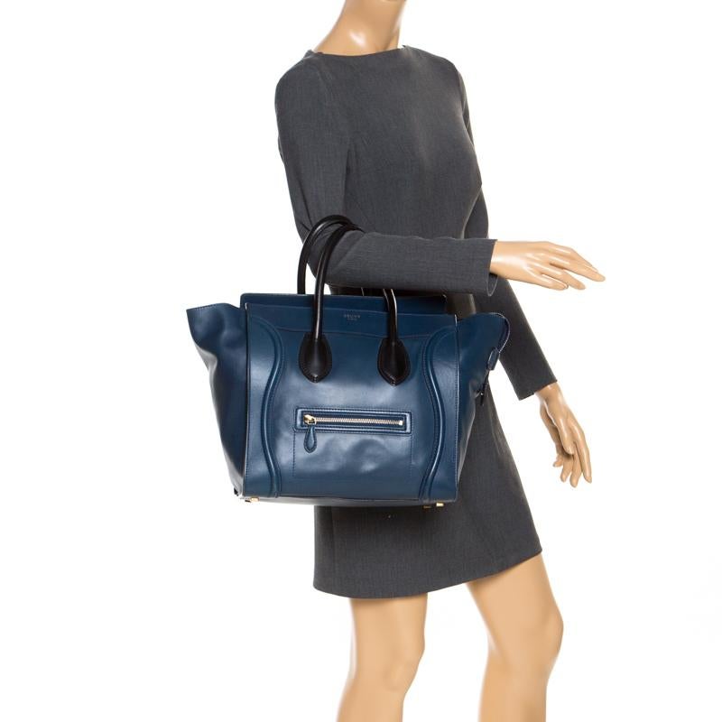 The mini Luggage tote from Celine is one of the most popular handbags in the world. This tote is crafted from leather and designed in a blue hue. It comes with black top handles and a front zip pocket. The bag is equipped with a well-sized leather