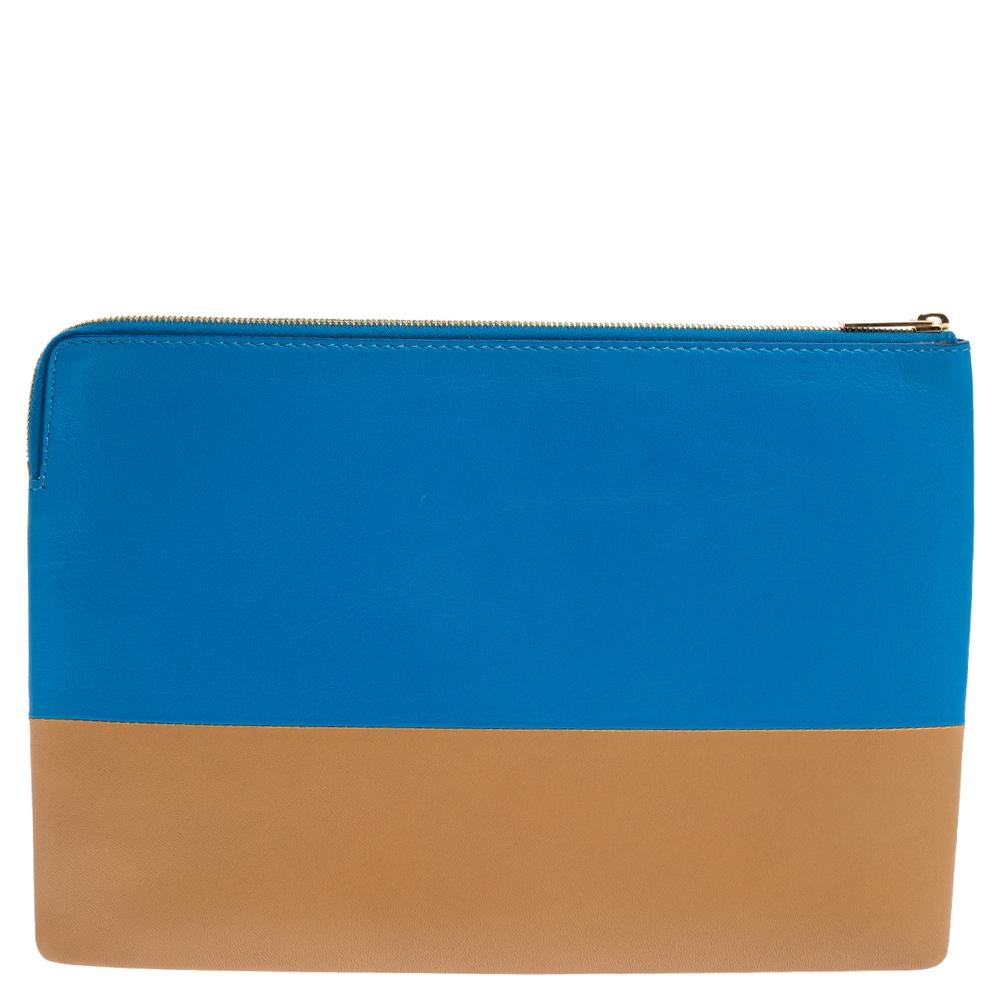 Grab this sporty two-tone blue and brown Celine leather 'Solo' clutch and look fabulous from day to night! It features a smooth leather exterior on its rectangular shape and a top zip closure. The Celine logo is embossed subtly in gold-tone at the