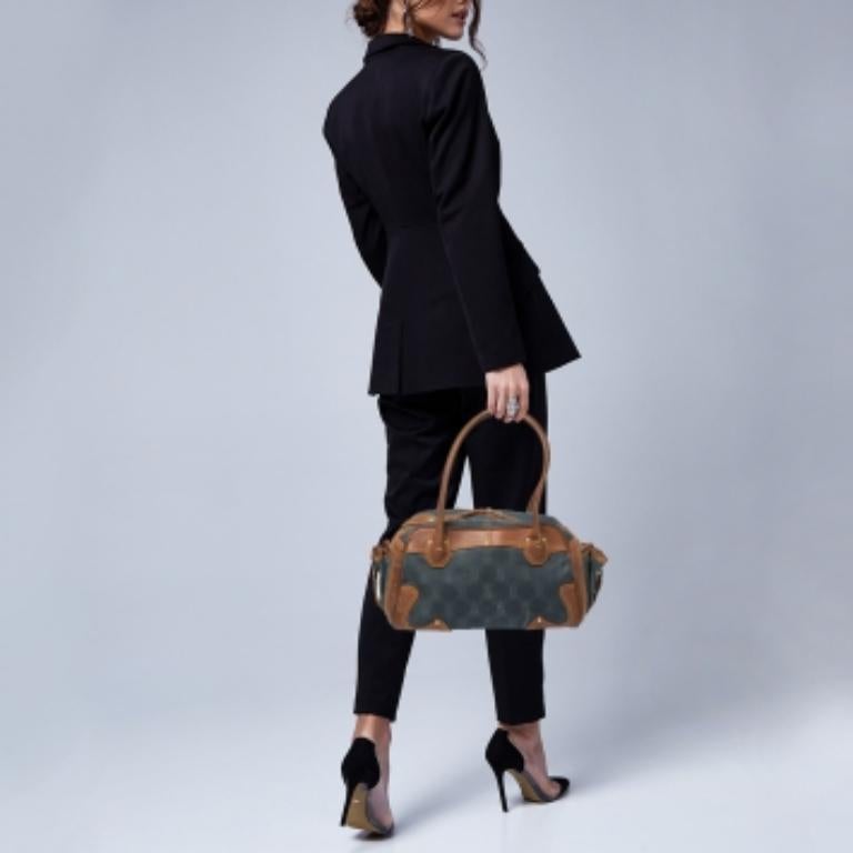 This Celine satchel is stylish and practical and deserves to be in every fashionista's closet. It is crafted from blue Macadam-coated denim and leather and is equipped with handles and pockets on the sides. The spacious bag opens up to a