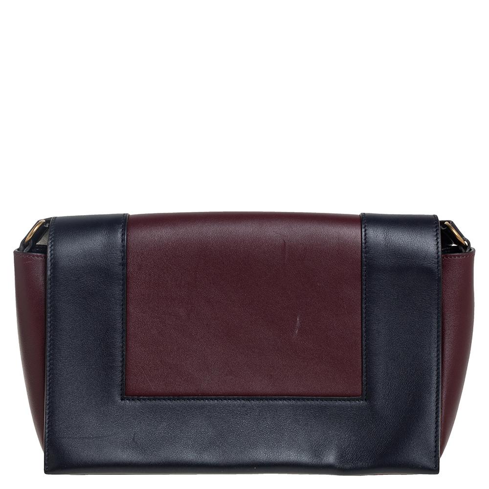 From the house of Celine comes this gorgeous messenger bag that will perfectly complement all your outfits. It has been luxuriously crafted from blue & burgundy leather and styled with a flap that opens to a well-sized leather interior. The bag is