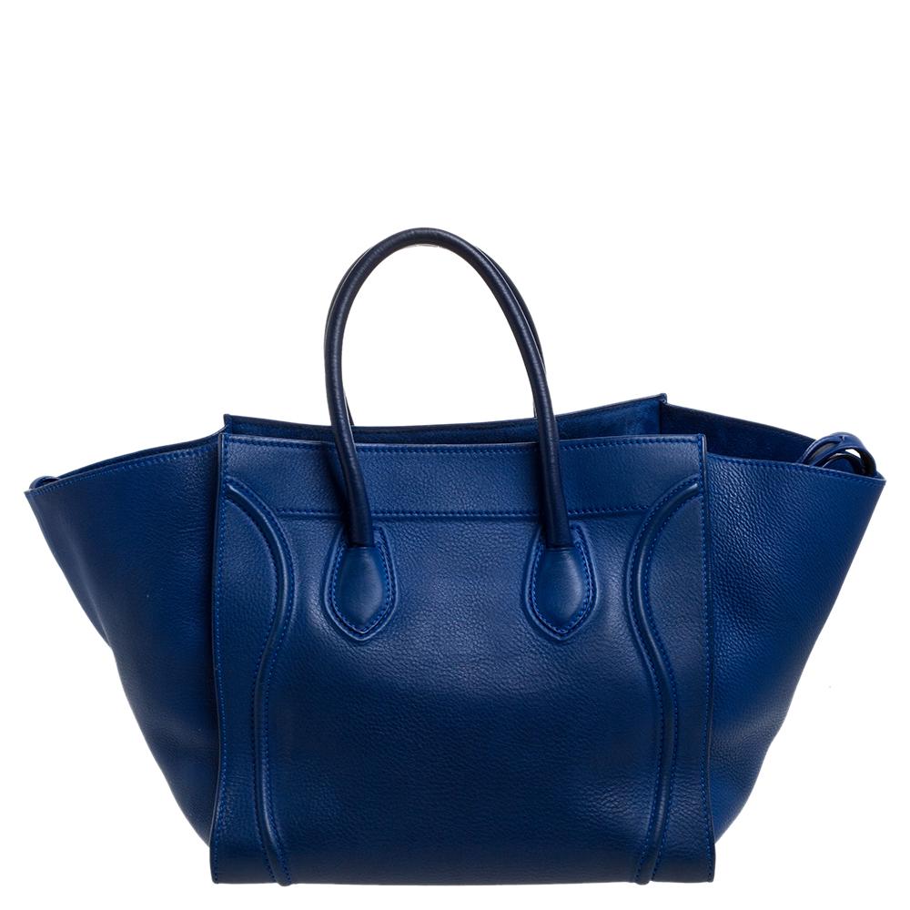 Celine released the Phantom as a newer version of its successful Luggage model. Unlike the Luggage toes, the Phantom has an open-top, wider wingspans, and a braided zipper pull. We have here the one in leather. It has two top handles, a blue shade,
