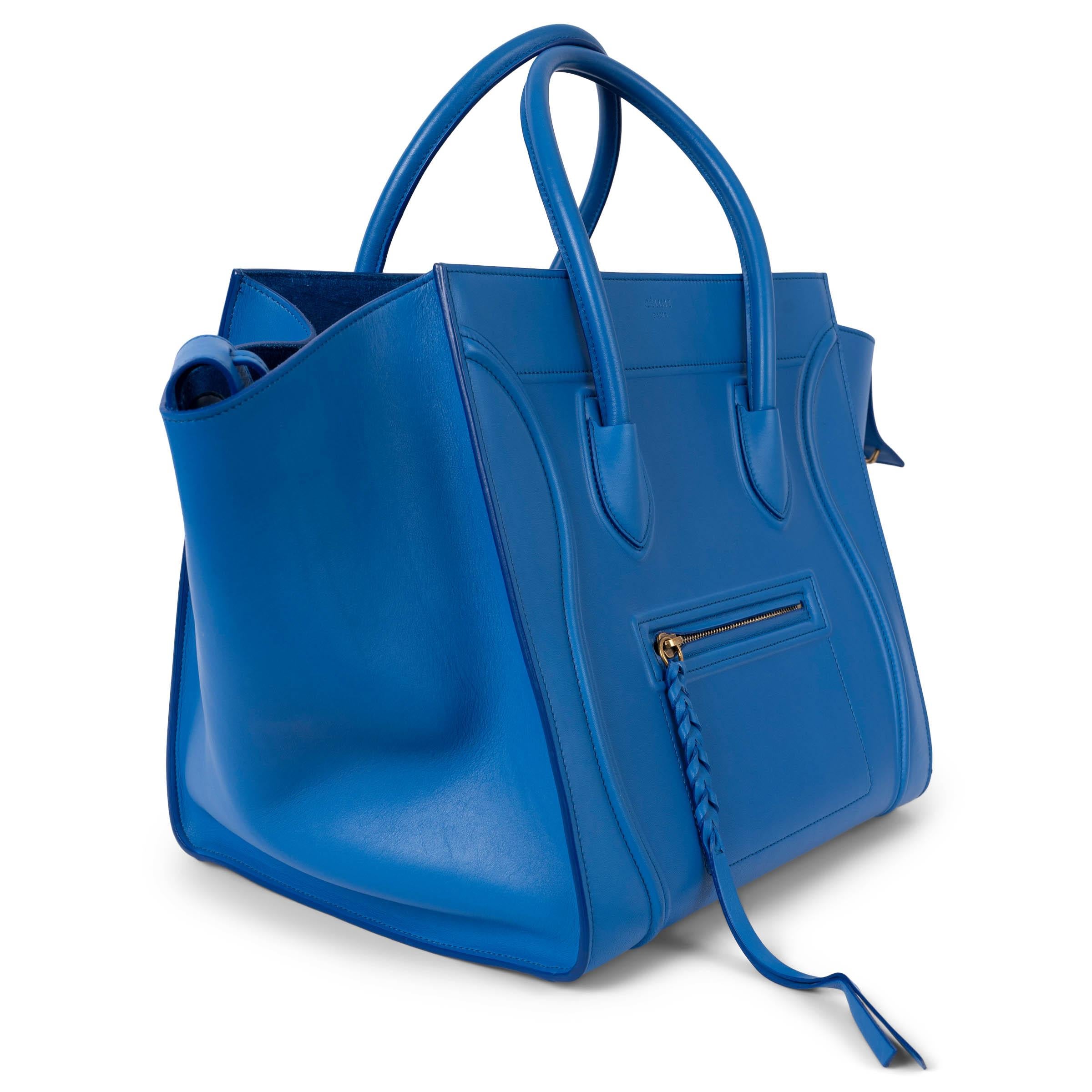 100% authentic Céline Medium Phantom Luggage tote bag in medium blue sm0oth calfskin featuring a small zip front pocket. Lined in suede with one zipper pocket against the back. Has been carried once or twice, however there are a few scratches on the