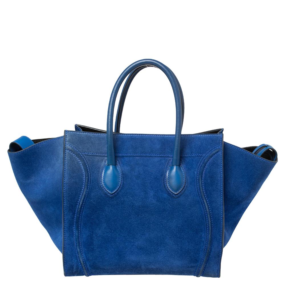 Celine released the Phantom as a newer version of their successful Luggage model. Unlike the Luggage toes, the Phantom has an open-top, wider wingspans, and a braided zipper pull. We have this one here in suede. It has two top handles, a lovely blue