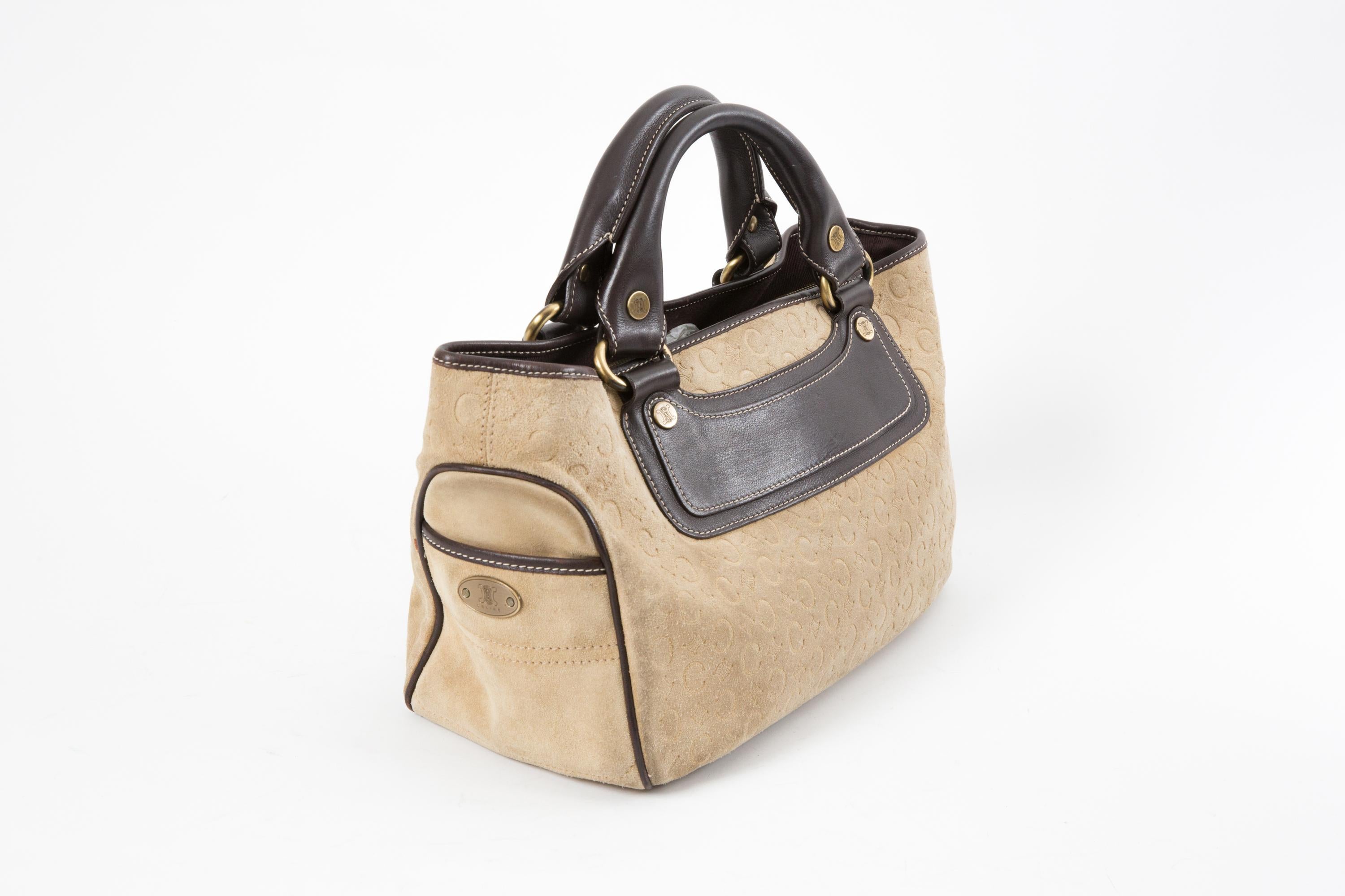 Celine Sand suede leather “Boogie” handbag featuring a signature “Triomphe” pattern on the suede, brown leather details, gold tone hardware, compartments with top logo zipper closure and interior cotton lining, side mini pockets. 
Circa 2000s
In